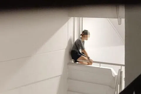 女子危坐在16楼与17楼间的楼梯口矮墙。（庄耿闻摄）