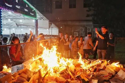踏入凌晨零时正，众人烧金纸迎接农历七月。（徐颖荃摄）