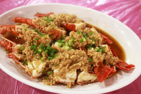 宴席菜色丰盛高档，当中包括金蒜粉丝蒸龙虾。（受访者提供）