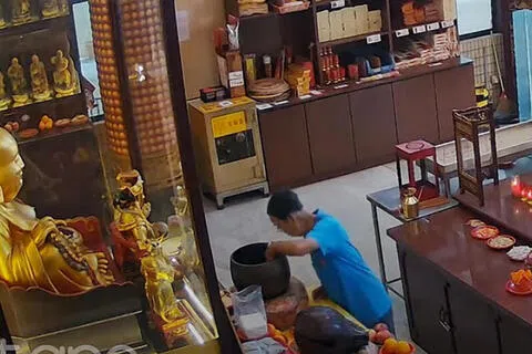 蓝衣老翁从“许愿钵”中拿取善款。（受访者提供）