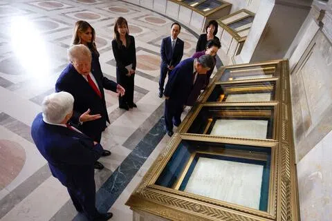 中国国家主席习近平与夫人彭丽媛9月25日参观美国国家档案馆，俯身细看确立美国联邦政府架构的宪法原件，美国总统特朗普伉俪（左二和三）陪同。国家档案馆是习近平三天国事访问的最后一站。（法新社）