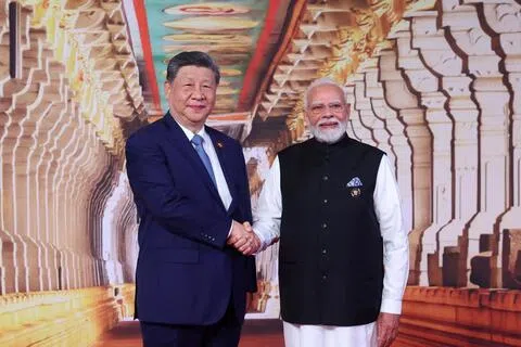 中国国家主席习近平（左）时隔七年访问印度，当地时间星期六（9月12日）出席金砖国家领导人峰会时与印度总理莫迪握手合影。（路透社）