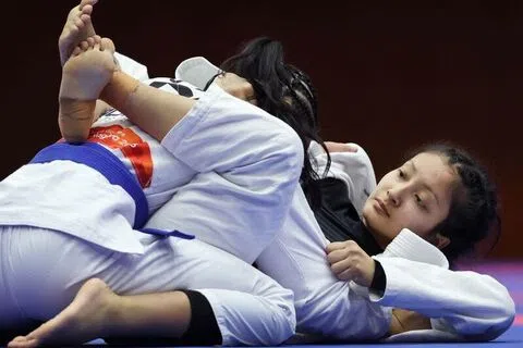 我国18岁巴西柔术小将索菲娅（右）在女子52公斤级复活赛中，仅以优势分不敌去年夺得世锦赛冠军的菲律宾老将珍娜，无缘铜牌战。（新加坡全国奥理会提供）