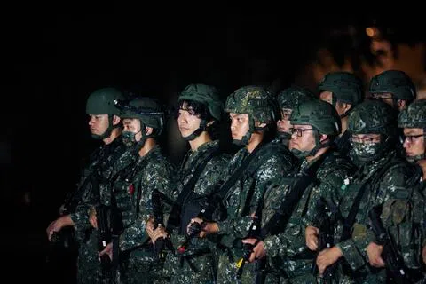 台湾军方在年度汉光演习中首度与海巡署联合举行反封锁护航演练，模拟护送载有重要战略物资的商船安全进港。图为士兵8月9日在军事演习期间列队，准备进行连级部队转移。（彭博社）