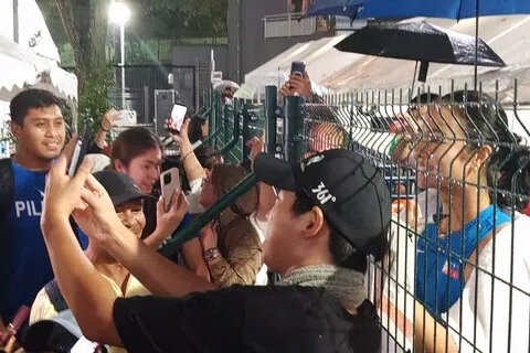 亚历山德拉（右）隔着围栏与菲律宾粉丝合照。（陈明耀摄）