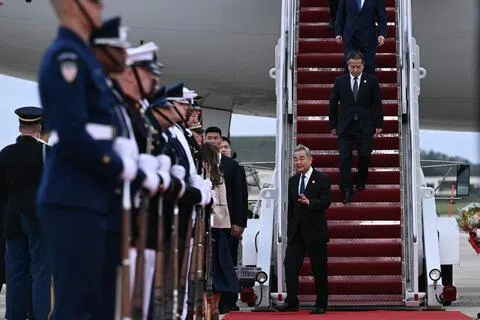 中国外交部长王毅（前）和中央政策研究室主任唐方裕（前二）星期三（9月23日）随中国国家主席习近平抵达美国马里兰州安德鲁斯联合基地，并与其他随行官员步下专机。（法新社）
