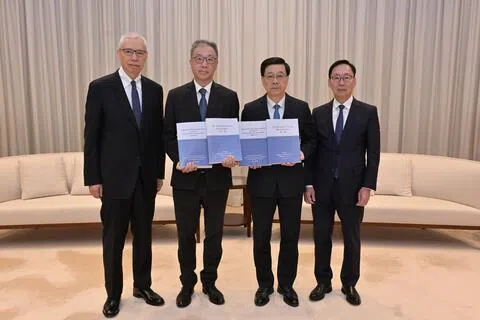 香港特首李家超（右二）10月22日收到独立委员会主席陆启康法官（左二）、委员陈健波议员（右一）及欧阳伯权博士（左一）呈交的大埔宏福苑火灾调查报告。（中通社）