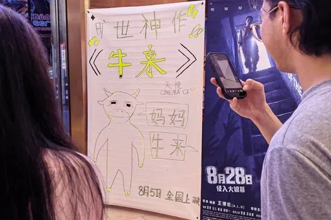 平台数据显示，截至星期天（8月23日），中国电影《牛来》累计票房已突破4200万元人民币（793万新元），观影人次超过150万。图摄于8月21日晚，北京市朝阳区一家电影院入口处摆放有电影《牛来》的手绘海报。（中新社）