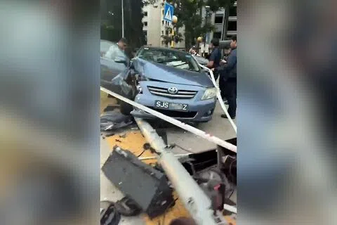 轿车疑打滑撞向交通灯柱。（取自网络）