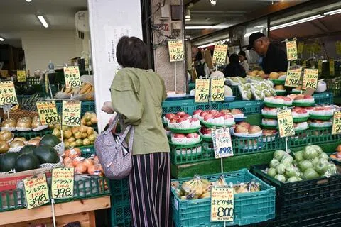 东京一个市场里，一名妇女在买菜。受通货膨胀和食品价格飙升冲击，日本家庭消费持续疲软，实际消费支出连续7个月同比下滑，凸显民生压力严峻。（彭博社）