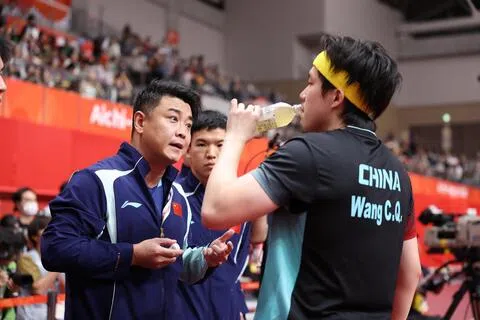 当地时间9月24日，在爱知·名古屋亚运会乒乓球男团决赛开始前，中国国乒男队主教练王皓（左一）指导中国队选手王楚钦（右）。中国队以2比3的比分不敌日本队，获得男团亚军。（新华社）