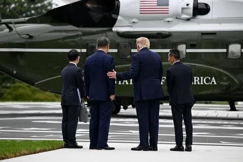 美国总统特朗普（右二）与中国国家主席习近平（右三）在白宫举行的会谈结束后，一起登上“海军陆战队一号”直升机参观。直升机停放在白宫南草坪新启用的直升机停机坪上。图为特朗普与习近平在登上直升机之前交谈。（彭博社）