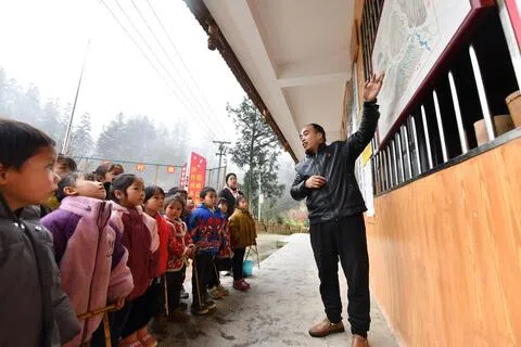 中国多地的闲置小学校舍，陆续改建为养老院、养老中心、长者食堂等。图为黔桂两省区交界处乌英苗寨教学点的孩子聆听教师讲解地理知识，摄于2024年3月15日。（新华社）