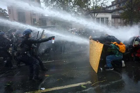 法国多地星期六（10月24日）再爆发第二波抗议示威；在巴黎一场由工会组织、获官方批准的游行中，警民爆发冲突，抗议者以木板为盾，抵御防暴警察和宪兵发射的水炮。（路透社）