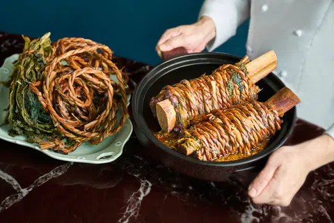 金蜓湾招牌菜九九梅菜安格斯牛肋，以九蒸九晒客家梅菜包裹牛肉，稻草扎紧后文火慢炖。（餐馆提供）