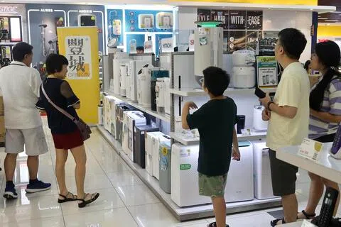 烟霾笼罩新加坡的天空，消费者趁周末到电器行选购空气净化机，了解不同型号的特点和使用方式。（邬福梁摄）
