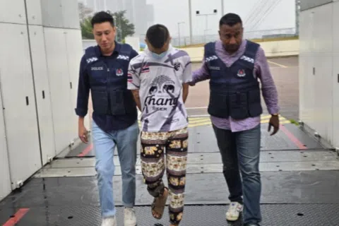 涉嫌协调冒充政府官员诈骗和洗钱活动的27岁马来西亚男子“Daxiang”（中）落网。（新加坡警察部队提供）