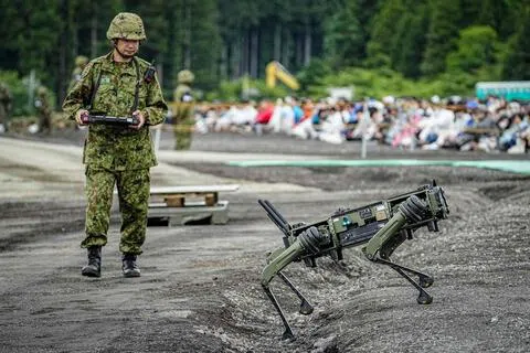 6月7日，日本陆上自卫队士兵在静冈县东富士演习场操控四足“机器狗”无人地面车辆。（法新社）