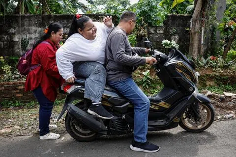 印尼茂物市15岁少女英丹乘坐电单车到医院接受检查。英丹因过度肥胖，12岁便辍学在家。她说，同学会掐她的胳膊、偷她的钱、朝她扔书本，“全班同学都在欺负我”。（路透社）