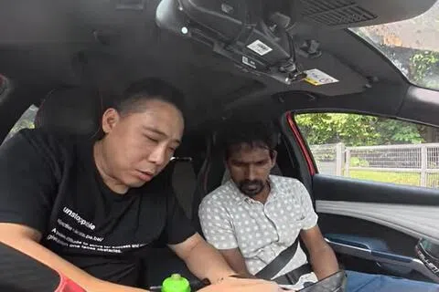 冯韦胜（左）在快速公路上看到客工骑行后，将车停在路肩，最终发现对方原来是误上快速公路，随后把他送往安全地点。（受访者提供）