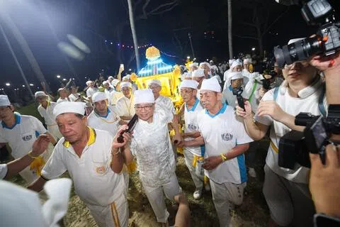 东海岸集选区议员、律政部长兼内政部第二部长唐振辉（中）星期天晚上与大批信众在东海岸参加九皇爷送驾活动。（陈渊庄摄）