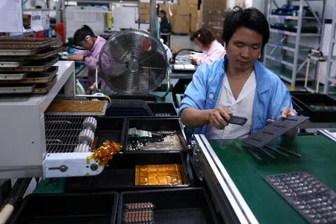 中国前七个月规模以上工业企业利润同比增长17.6%，其中电子行业的利润增长成为主要支撑。图为3月16日，中国广东省东莞市的一家工厂内，一名员工在印刷电路板生产线上工作。（路透社）