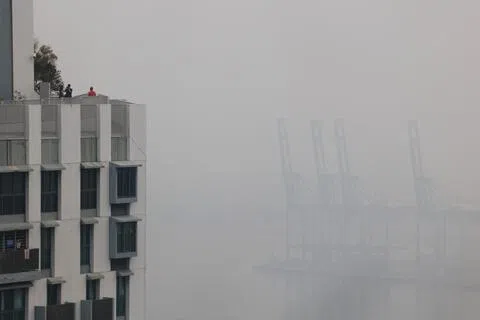 全国一小时PM2.5悬浮颗粒浓度星期一下午持续攀升，许多地区朦胧一片。南部的一小时PM2.5悬浮颗粒浓度于傍晚5时达到140；从达士岭组屋邻里的高处望去，布拉尼集装箱码头的起重机几乎已经看不见。（蔡家增摄）