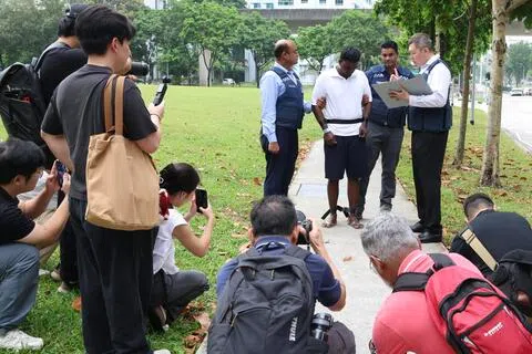 涉嫌参与此案的25岁马来西亚籍男子（白衣），星期一（10月26日）上午被押回榜鹅临谷坪一带重组案情。（郑一鸣摄）