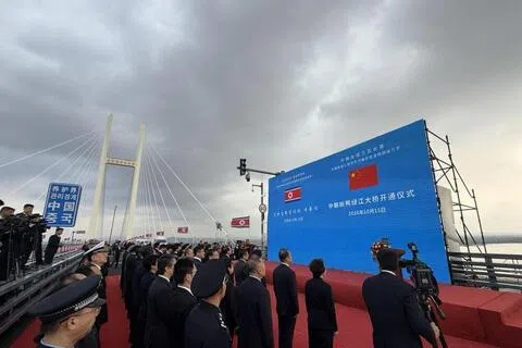 中朝新鸭绿江大桥在建成近12年后终于开通。照片显示，出席者在大桥上列队站好，为开通仪式做准备。（取自央视新闻客户端）
