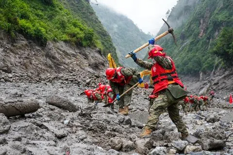 尼泊尔与中国西藏交界处的喜马拉雅山区发生严重山洪和泥石流后，武警西藏总队日喀则支队救援官兵8月29日在救援现场，配合大型机械组织河道一侧的搜救和清淤工作。（中新社）