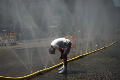德国6月底多地气温超过40摄氏度，单在一周内就有约9600人死于与高温相关原因。图为一名男子6月25日在德国西部科隆，利用设在街道的喷水管降温。（法新社）