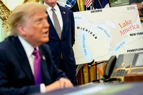 特朗普在白宫椭圆形办公室签署行政令时，旁边放了一张写有“美国湖”的地图。（路透社）