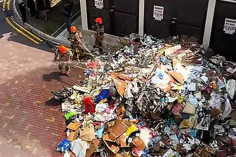 根据TikTok网民“_brotherbearrr”发布的视频，大量纸皮和旧衣物等可回收物品被卸在组屋楼下马路后，不仅冒出火光，还升起阵阵白烟。（取自TikTok用户@_brotherbearrr）