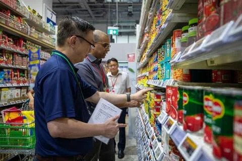 在新加坡食品局储备粮食供输演练参与视察的教育部兼永续发展与环境部高级政务部长普杰立医生（左二），实地了解零售门店的日常运营情况。（新加坡食品局提供）