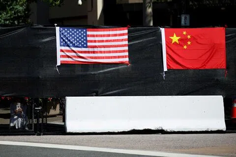 中国商务部以案情复杂为由，延长两项对美贸易壁垒调查至12月27日。图为中国国家主席习近平与夫人彭丽媛9月25日正式访问美国华盛顿白宫当天，一道安保围栏上悬挂着美国和中国国旗。（路透社）