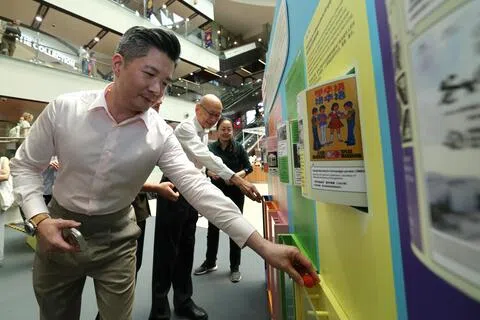 新加坡华族文化中心星期二（8月25日）于牛车水唐城坊正式启动“共绘新章：塑造新加坡华族历史文化馆”巡回展，邀请公众就未来的文化馆展览内容与呈现方式提出建议。华族文化中心总裁陈子宇（左一）与文化馆咨询委员柯木林（左二）在文化馆拟议的六大内容支柱中投选他们各自最关心的主题。（梁麒麟摄）