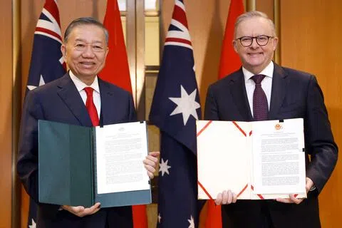 8月11日，苏林（左）和阿尔巴尼斯在堪培拉国会大厦举行双边会晤后交换文件。（法新社）