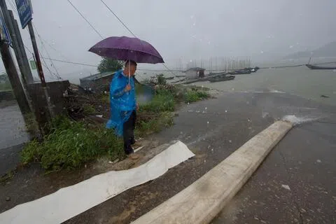 位于闽浙两省交界的福建省福鼎市，受台风“沙德尔”影响，星期五（8月28日）普降暴雨。图为福鼎市前岐镇工作人员在海边查看排涝情况。（新华社）