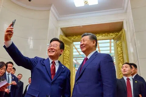 中国国家主席习近平星期六（8月15日）致电韩国总统李在明，祝贺韩国政府成立78周年。图为李在明（左）今年1月访华时，在北京人民大会堂用习近平赠送的小米手机自拍留念。（法新社）