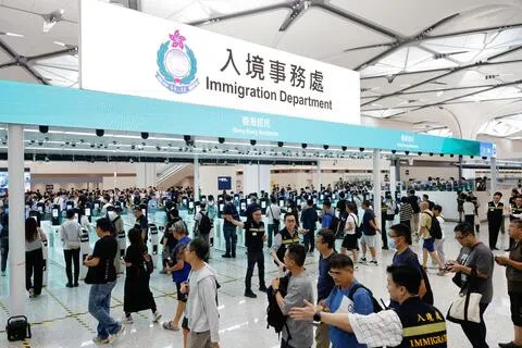 新皇岗口岸8月22日举行大型演练，香港动员逾1万名公务员及约千辆汽车，模拟假日高峰期通关情况，测试港方口岸区人流、车流处理能力。演练期间连续进行三轮、每轮约2500人的高峰人流压力测试，整体流程大致顺畅。图为香港入境处人员指引人流过关。（香港中通社）