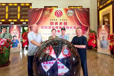 中国著名相声演员郭德纲原定本周在山东烟台举行的三场演出，因场地原因展期。图为麒麟剧社创始人郭德纲（右一）等嘉宾8月3日在麒天大胜・麒麟剧社戏友演唱大赛新闻发布会上，启动比赛。（中新社）