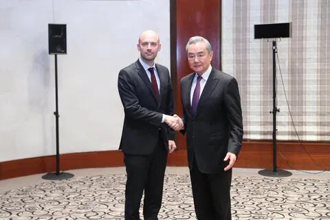 中国外长王毅星期一（9月14日）应约同法国外长巴罗通电话，强调保护主义提升不了欧洲竞争力。图为王毅（右）2月13日在出席慕尼黑安全会议期间会见巴罗。（新华社）