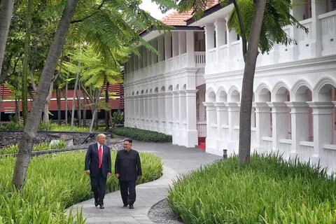 如果将“说服金正恩放弃核武器”定义为成功，特朗普的这次外交尝试注定会失败。图为2018年6月12日，特朗普与金正恩在新加坡举行峰会期间，午餐后在圣淘沙的酒店外散步。（海峡时报）