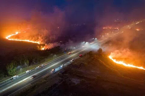 无人机航拍画面显示，南苏门答腊省奥甘伊利尔（Ogan Ilir）地区一条收费公路附近星期五（8月28日）晚上发生山火，现场弥漫着浓烟。（路透社）