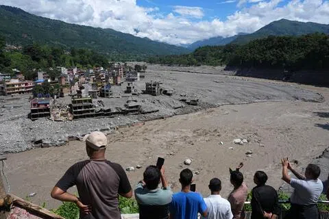 尼泊尔北部边境拉苏瓦地区星期三（8月26日）暴发山洪，部分道路、桥梁和村镇被毁，当地只能依靠直升机转运人员和物资。当地救援和灾后清淤工作目前仍在继续。图为当地时间8月27日，尼泊尔民众眺望努瓦果德县崔树里镇。（中新社）