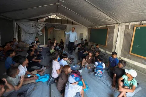 9月19日，在加沙地带南部汗尤尼斯一所用帐篷搭建的临时校舍，学生们迎来新学期的第一天。（路透社）