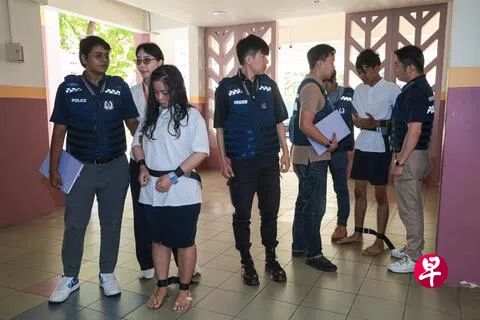 马国籍19岁青年和印尼籍25岁女子受大耳窿指示，到多个组屋单位泼漆讨债被捕。两人于星期三（8月5日）早上被押回其中两个案发地点协助调查。（李冠卫摄）