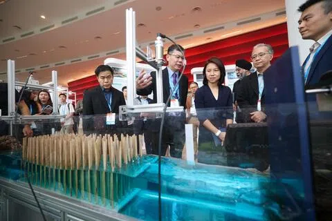 在新加坡海岸防护与防洪研究所举办的国际研讨会上，永续发展与环境部高级政务次长吴函燕（右三）了解一项由本地科研人员现场演示的海岸植被和水流智能监测技术。（陈渊庄摄）