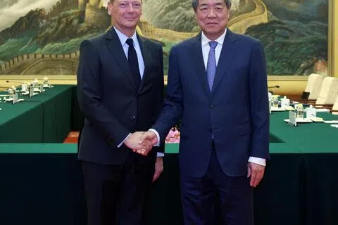 中国副总理何立峰（右）10月13日在北京人民大会堂与法国总统外事顾问博纳会面。（新华社）