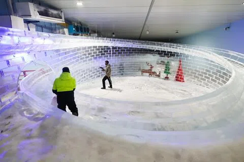 雪城每星期一闭馆以进行例常维护工作。34岁的客户服务专员兼教育专员马歇尔（左）和33岁的技术员帕拉马南丹向冰滑梯喷水，确保冰滑梯厚实滑溜。（张俊杰摄）